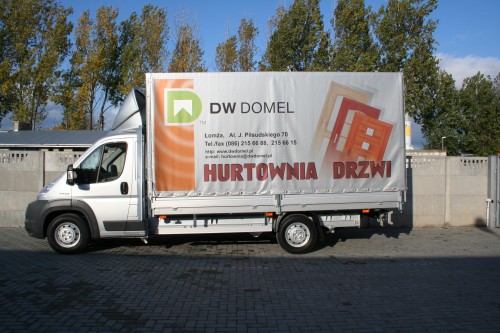 Plandeka reklamowa firmy DW Domel na zabudowie skrzyniowej.