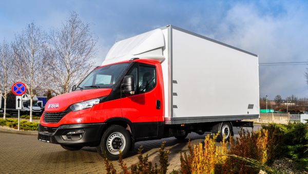 Czerwone Iveco Daily z kontenerem